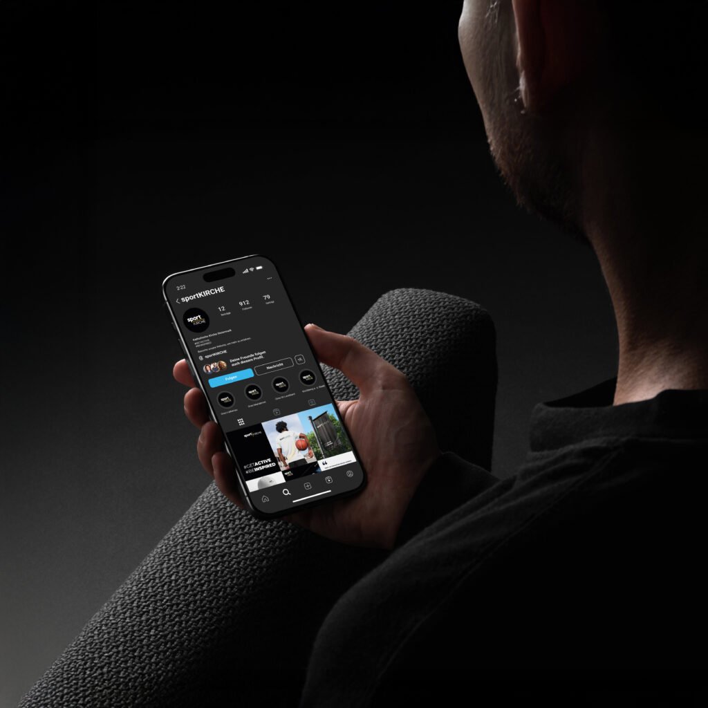 Person hält Smartphone mit geöffneter Instagram-Seite der „Sportkirche“