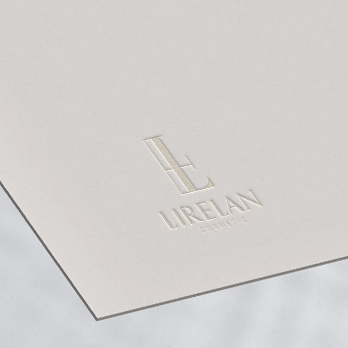 Geprägtes Monogramm-Logo von LIRELAN COSMETIC auf cremefarbenem Feinstpapier