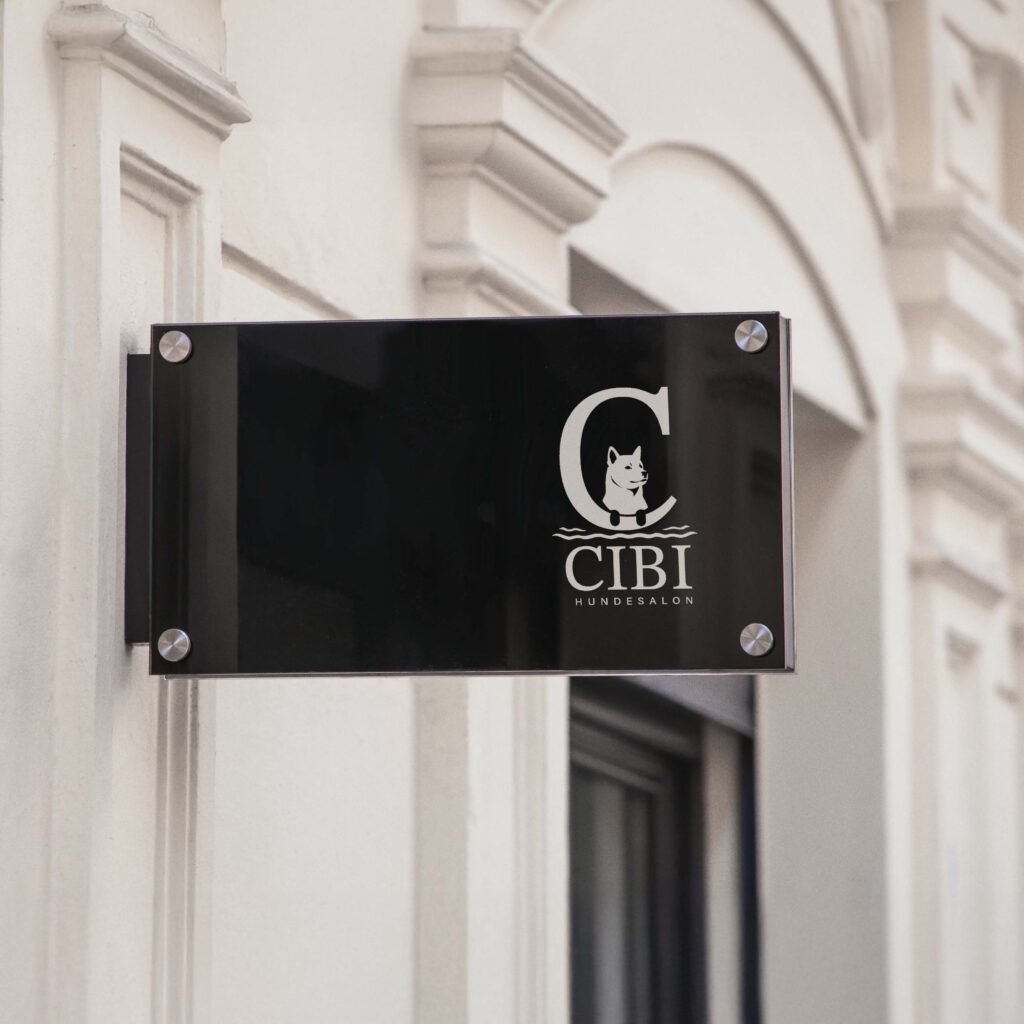 Schwarze Acrylglas-Schild mit Logo „CIBI Hundesalon“ an weißer Fassade – modernes Außenbranding