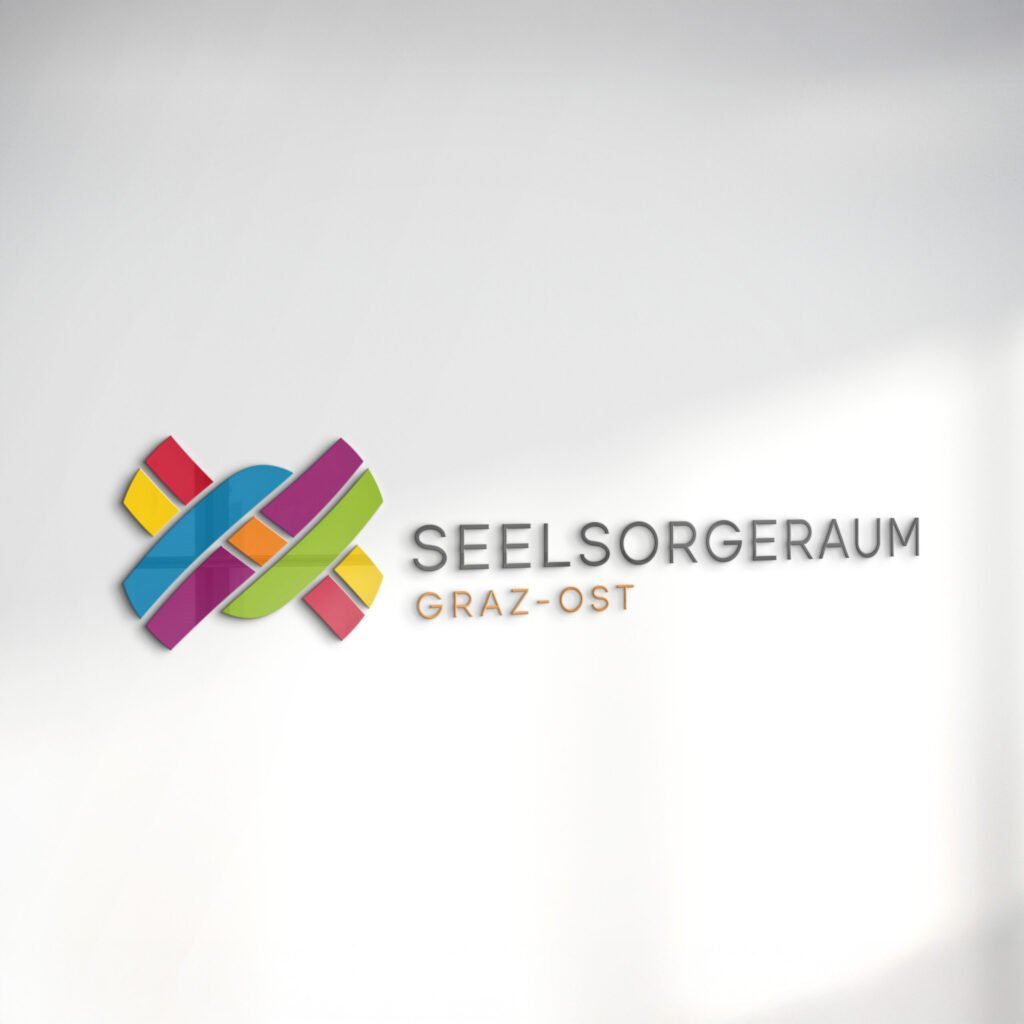 3D-Darstellung des Logos Seelsorgeraum Graz-Ost an einer hellen Wand, bestehend aus ineinander verflochtenen, farbigen Elementen und Schriftzug „Seelsorgeraum Graz-Ost“
