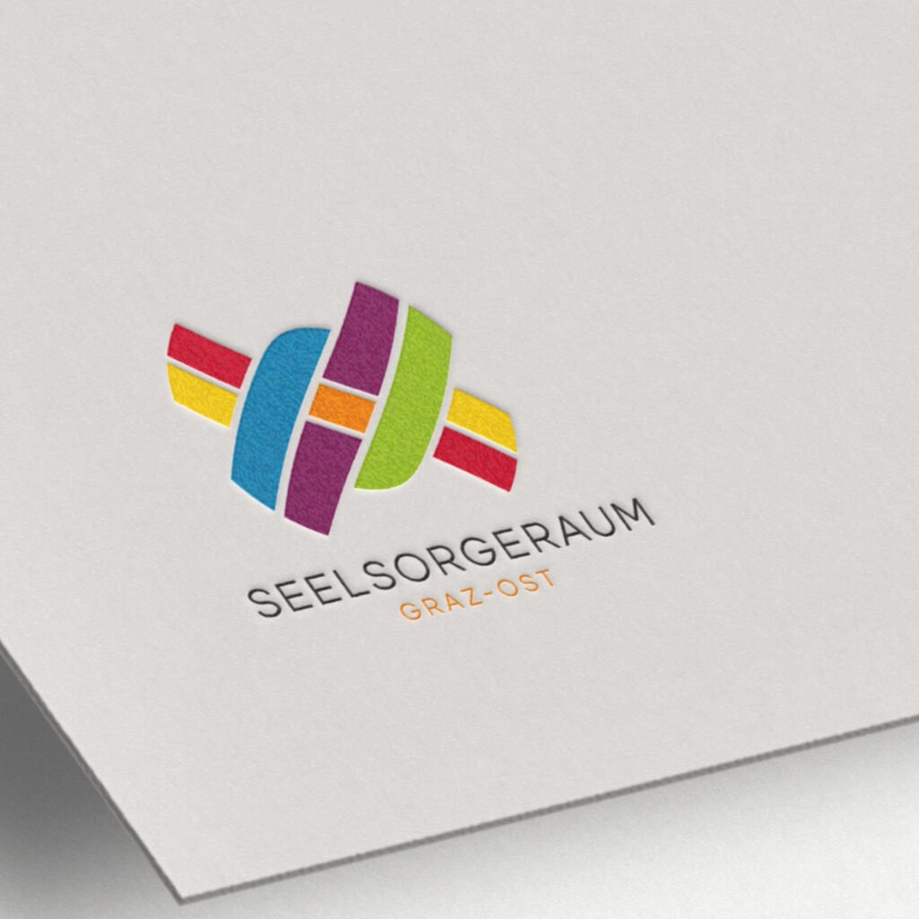 Geprägtes Logo des Seelsorgeraums Graz-Ost in bunten Farben auf weißem Papier.