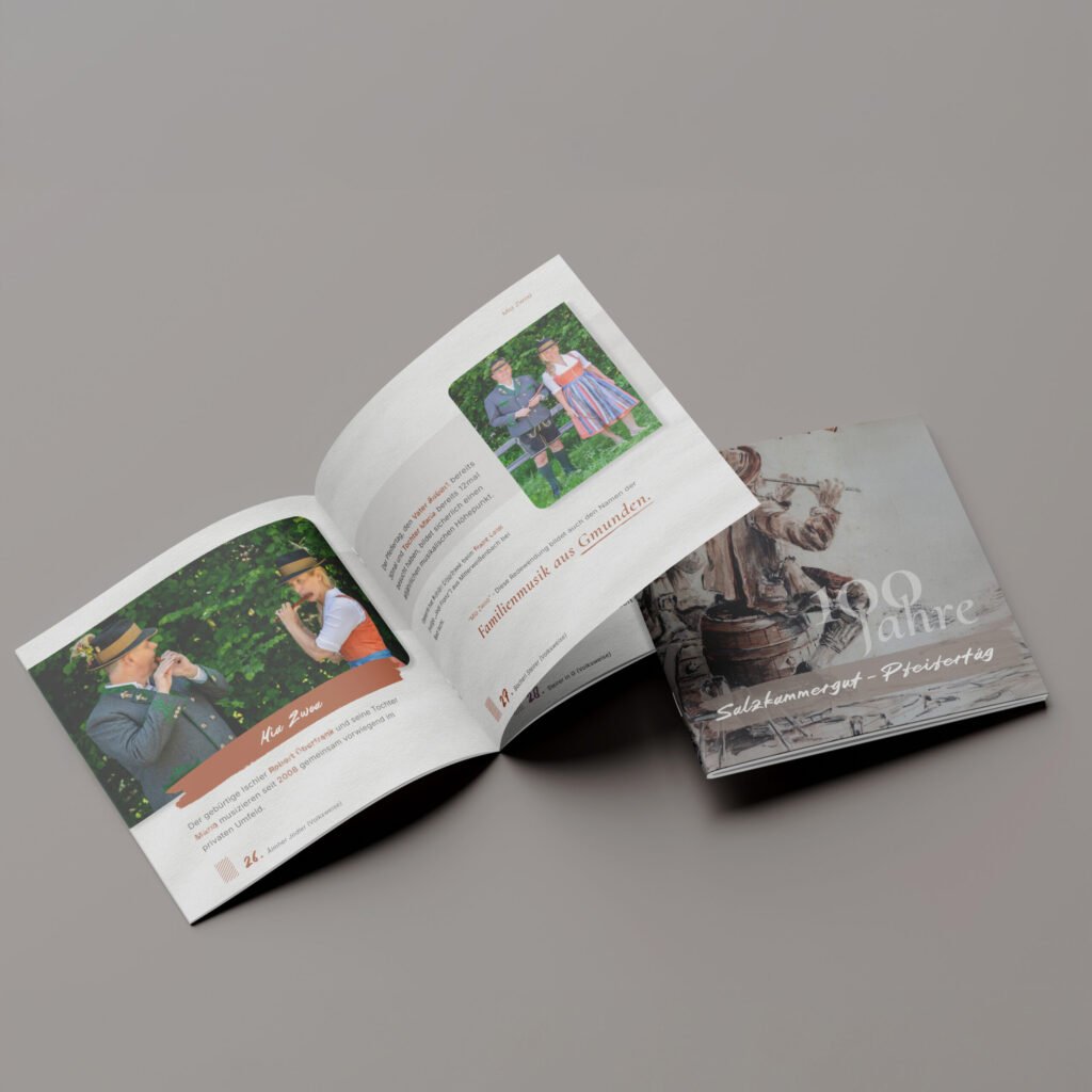 Geöffnetes Booklet mit Fotografien des Pfeifertags, daneben das geschlossene Jubiläums-Booklet zum 100-jährigen Pfeifertag.