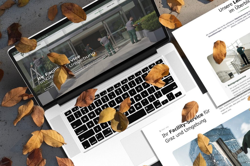 Laptop mit geöffneter Website von Hammer & Hecke Facility-Service zwischen Herbstlaub, Webdesign für Reinigungsservice Graz, modernes responsives Screendesign für Gebäudereinigung
