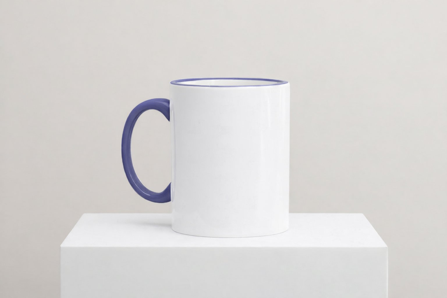 Weiße Keramiktasse mit Cambridge Blauem Henkel und Cambridge Blauem Innenrand auf weißem Podest vor neutralem Hintergrund