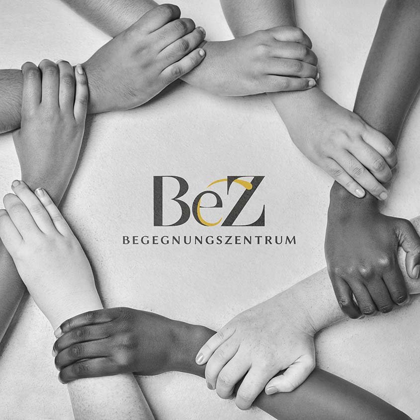 Verschiedene Hände halten sich im Kreis, darunter das BeZ-Logo